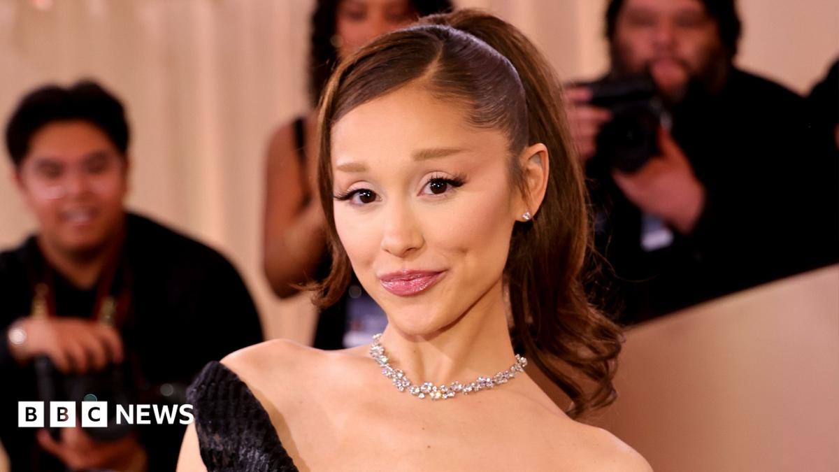 Ariana Grande poses for the cameras at the Golden Globes earlier this year. She is wearing a black dress and diamond necklace and has her hair in a ponytail.