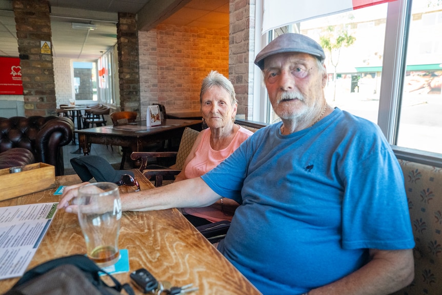 An older man and woman sitting at a pub booth.