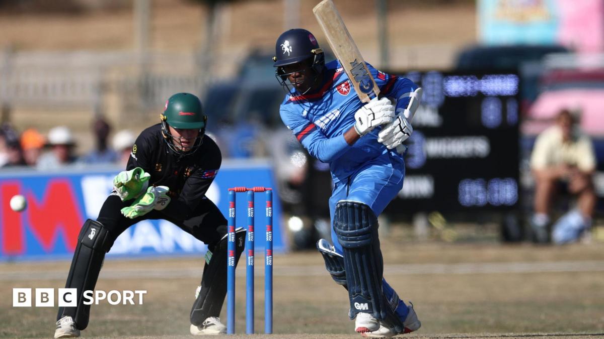 Daniel Bell-Drummond hits a shot for Kent against Leicestershire in the One-Day Cup while wearing a predominantly blue kit in front of a blue wicket with a wicketkeeper in green behind him