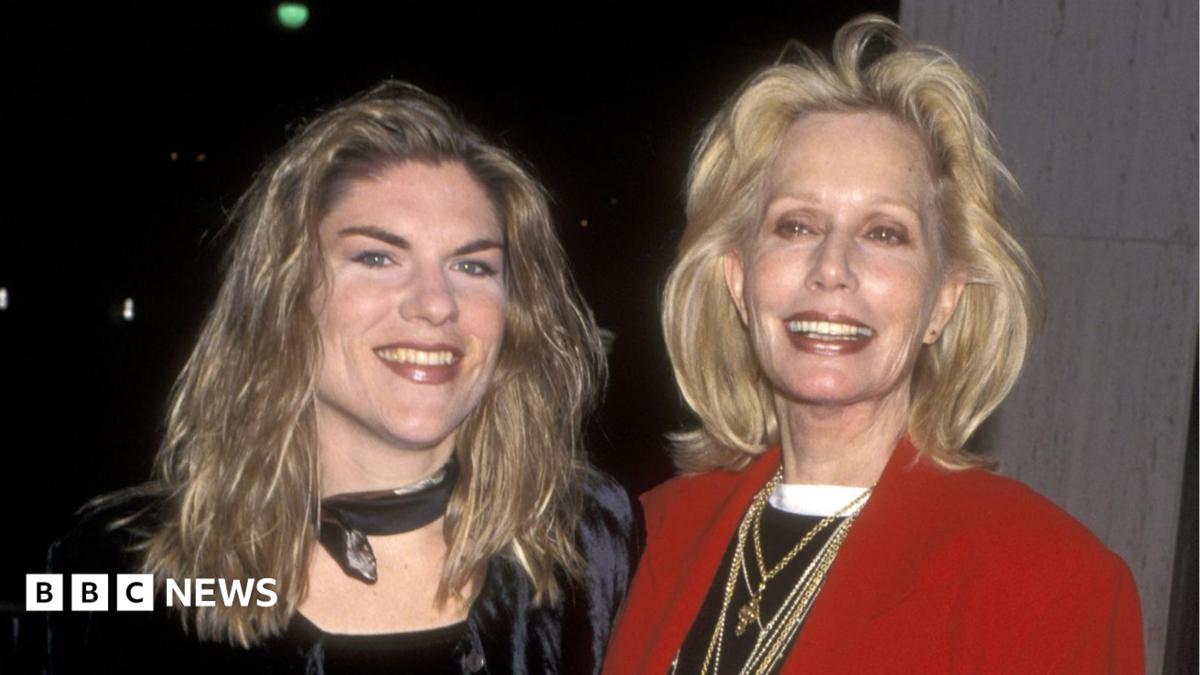 Claire Kellerman pictured with her mum actress Sally Kellerman in 1997. Claire has long, fair hair and wears a dark top and neck scarf. Sally has shoulder-length blonde hair and wears a black top, several gold necklaces and a red blazer. Both smile for the camera.