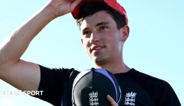 John Turner wearing a blue England top and holding a blue England cap