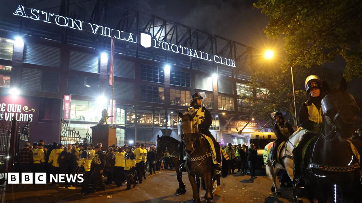 Mounted police officers wearing high-vis jackets over uniform stand outside Aston Villa Football ground. Behind them many other officers wearing bright yellow jackets can be seen