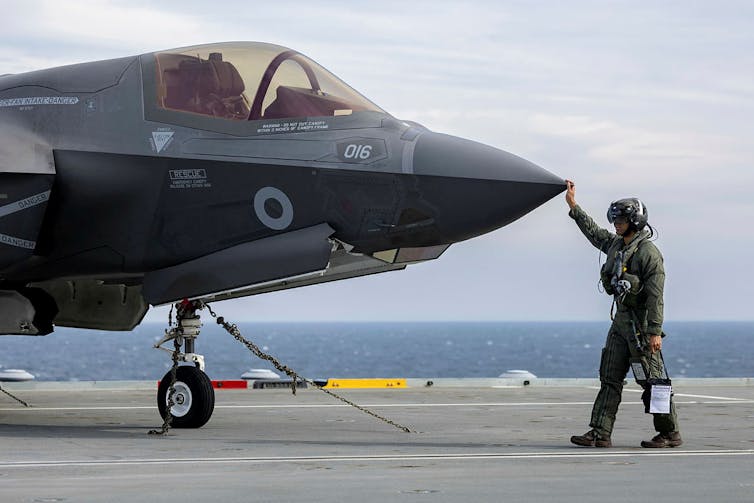 F-35 Pilot conducts walk around checks before starting up jet.