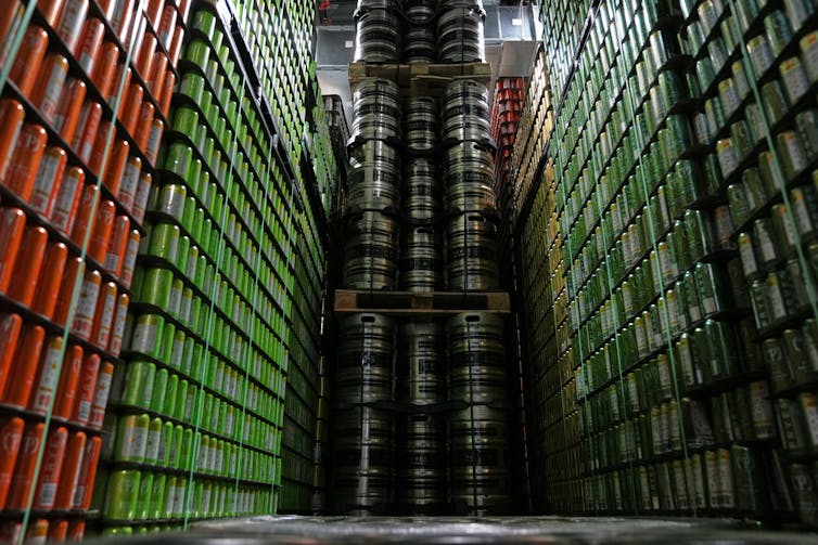Cans and kegs of craft beer are stacked on top of one another in a warehouse