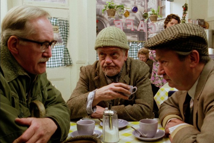 The cast of Last of the Summer Wine. The cast of Last of the Summer Wine in the feature length special, Getting Sam Home. They are sat around a small café table, talking closely in a huddle.