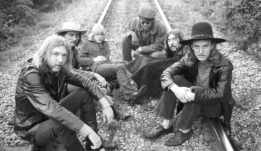 The Allman Brothers Band seated on a railway line