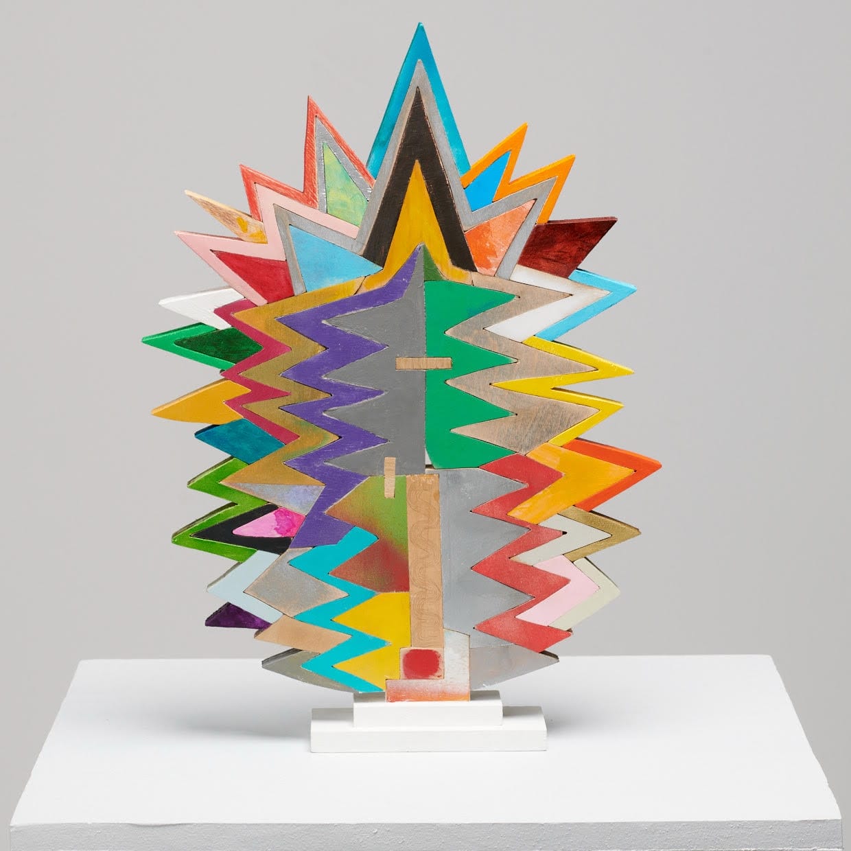 a small abstract wooden sculpture painted in vibrant colors by damien hoar de galvin