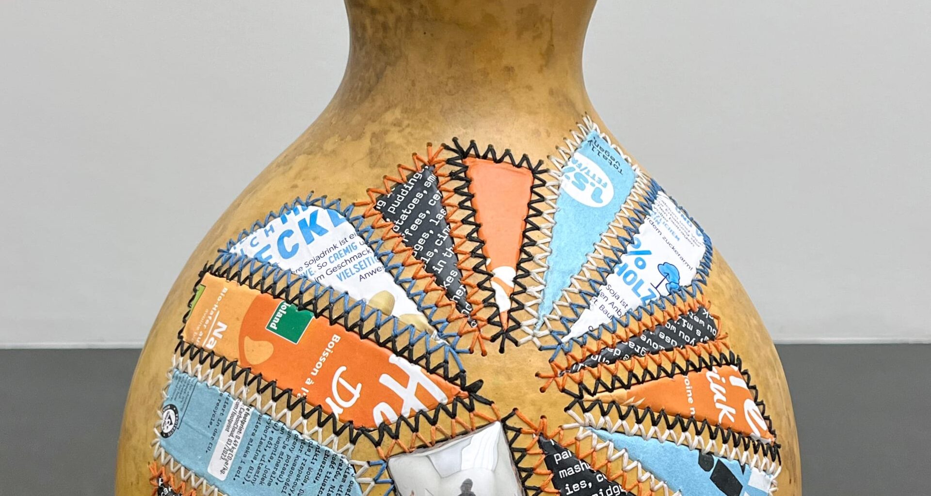 a gourd with colorful aluminum patches sewn on the side