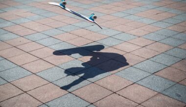 a street photo of a skateboard mid-air with the shadow of the skateboarder below