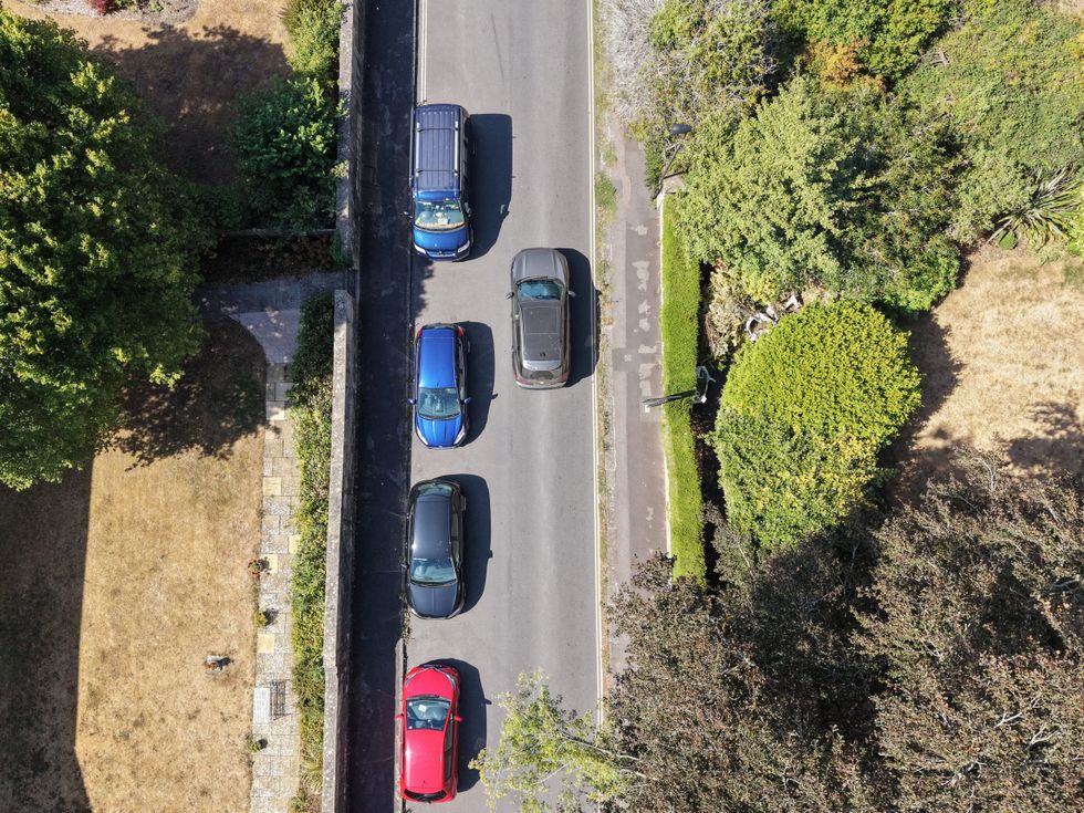 SUVs parked on road with other large cars