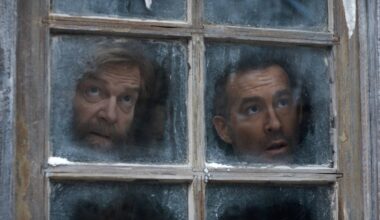 L to R: Kenneth Branagh as Nikolai Ustinov and Ryan Reynolds as Troy Kelly looking out of a frosted windown in Mayday