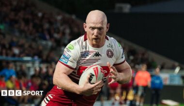Liam Farrell scoring a try with the ball in his right hand for Wigan