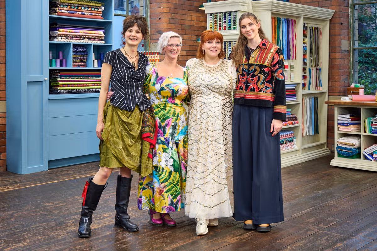 Four women stood smiling in a fabric workshop