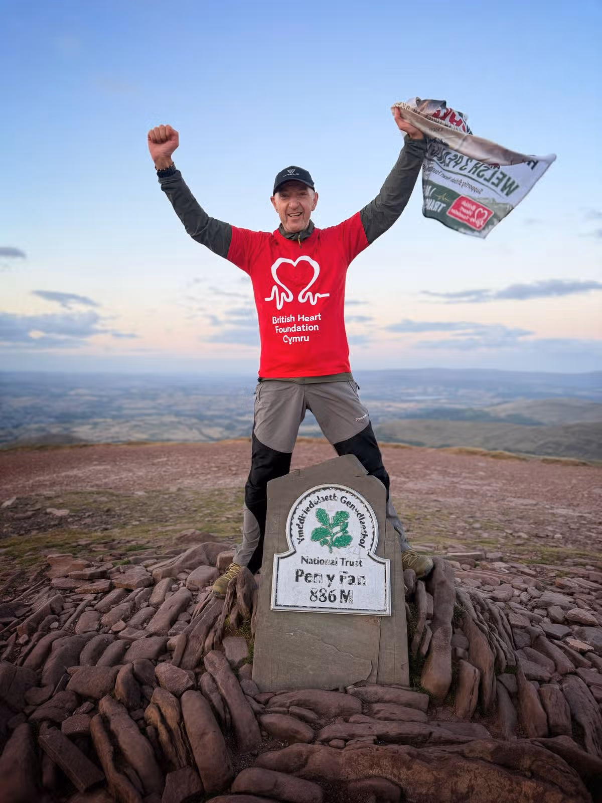 A jubilant man at the top of a mountain