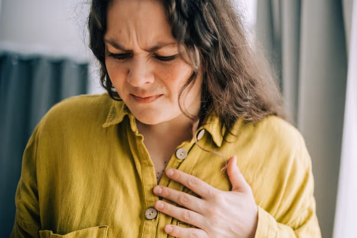 Woman suffering from chest pain holding hand over heart