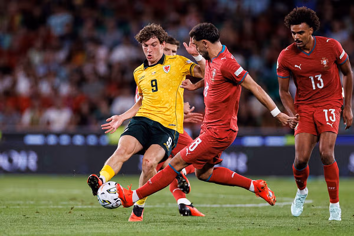 LISBON, PORTUGAL - SEPTEMBER 24: Lewis Koumas of Wales (L) fights for the ball with Bruno Fernandes of Portugal (C) during the UEFA Nations League 2026/27 group phase match between Portugal and Wales at Estadio Jose Alvalade on September 24, 2026 in Lisbon, Portugal. (Photo by Miguel Lemos/Eurasia Sport Images/Getty Images)