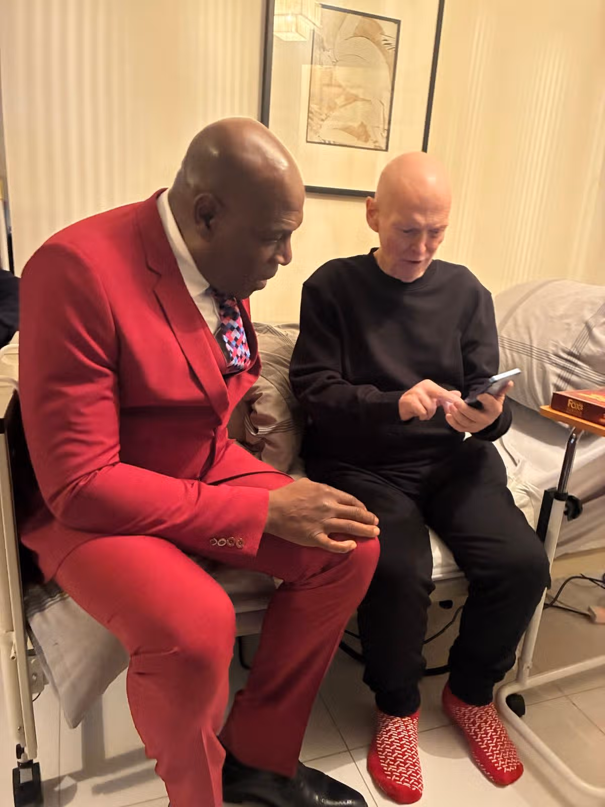 John taking the opportunity to show Frank Bruno photos of his own flamboyant suits on his phone