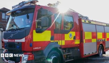 A stock photo of a fire engine driving down a residential street