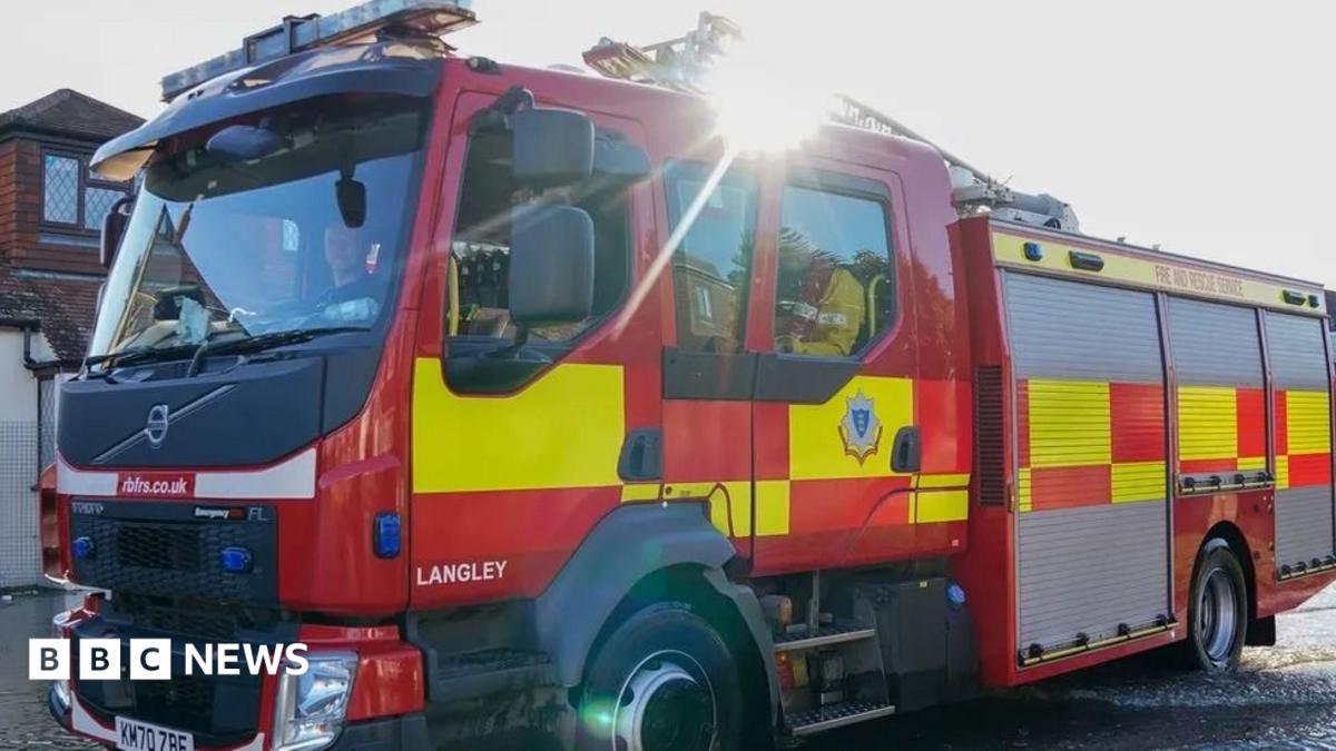 A stock photo of a fire engine driving down a residential street