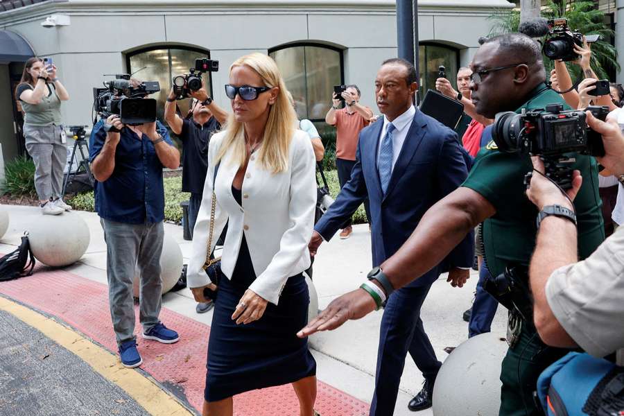 Tiger Woods flanked by his girlfriend, Vanessa Trump, leaves the courthouse