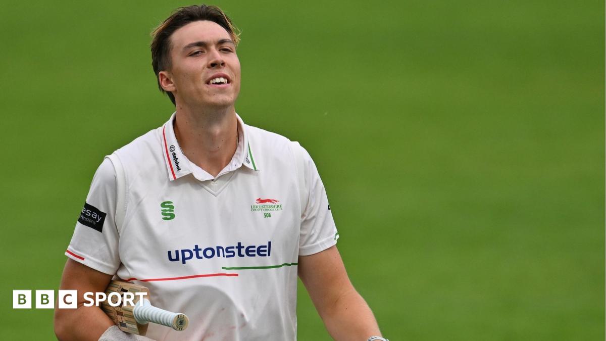 Josh Hull raises his bat to celebrate his half-century