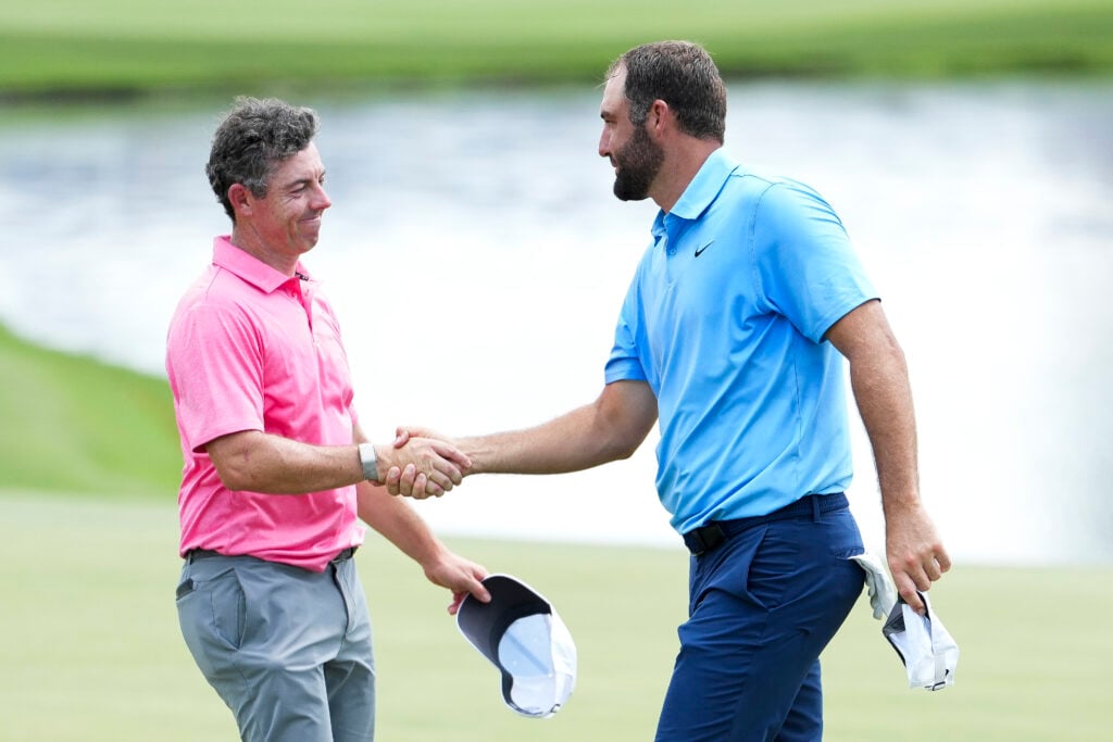 Scottie Scheffler of the United States shakes hands with Rory McIlroy of Northern Ireland on the 18th hole green during the first round of the FedEx St. Jude