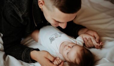 Man holding the baby really closely while on bed