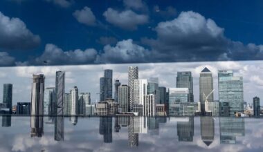 London financial district skyscrapers reflecting in water, under a dramatic cloudy sky