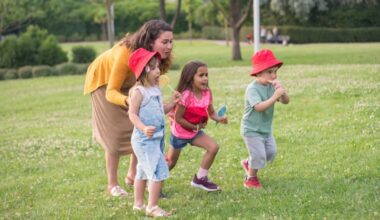 Woman playing with three small children with lollipop outdoors