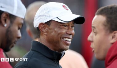 Professional golfer and Stanford Cardinal alumni Tiger Woods stands on the sidelines during the first half of the Stanford Cardinal game against the Miami Hurricanes at Stanford Stadium