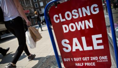 Closed sign hanging on small business door, symbolizing temporary closure or operational pause amid challenging market con...
