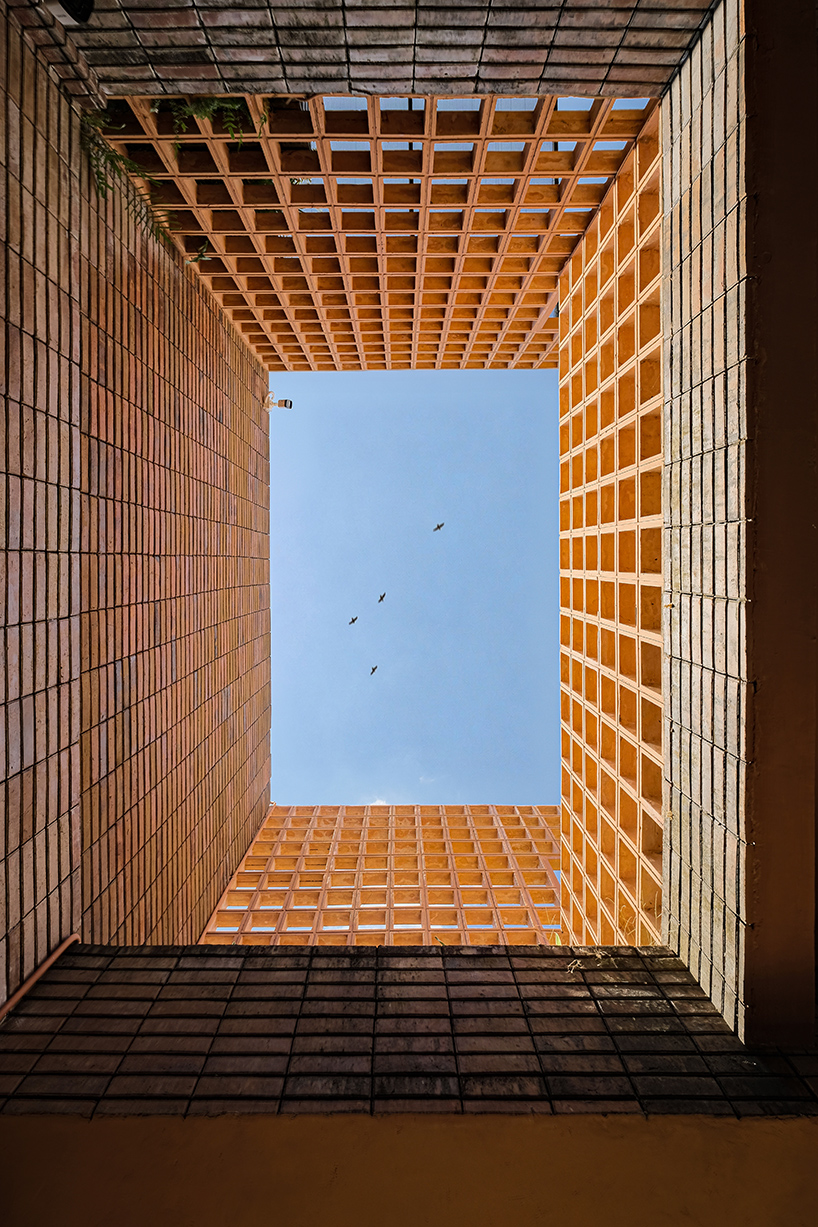 local stone, brick and terracotta screens layer across three-story gathering space in indonesia - 4