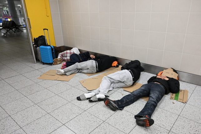 Travellers lay on the floor with their luggage at the South Terminal of London Gatwick airport near Crawley, southern England on September 9, 2026, following second day of major disruption due an issue affecting the NATS air traffic control systems. UK travellers faced more misery on September 9, with more than 150 flights scrapped across the country, as Britain's air traffic control service scrambled to recover from a technical glitch that sparked chaos. (Photo by JUSTIN TALLIS / AFP via Getty Images)