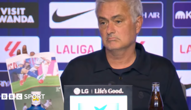 A frowning Jose Mourinho at his news conference with screenshots of incidents he believed should have brought about red cards for Atletico Madrid players. In the background is an advertising board featuring sponsor and competition logos.