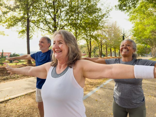 A small group of seniors stretching to exercise in the public park