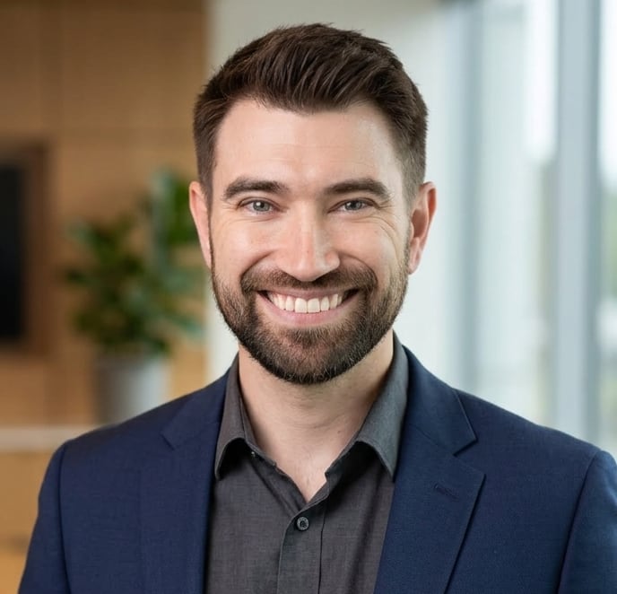 A man with a beard smiles for a portrait photo.