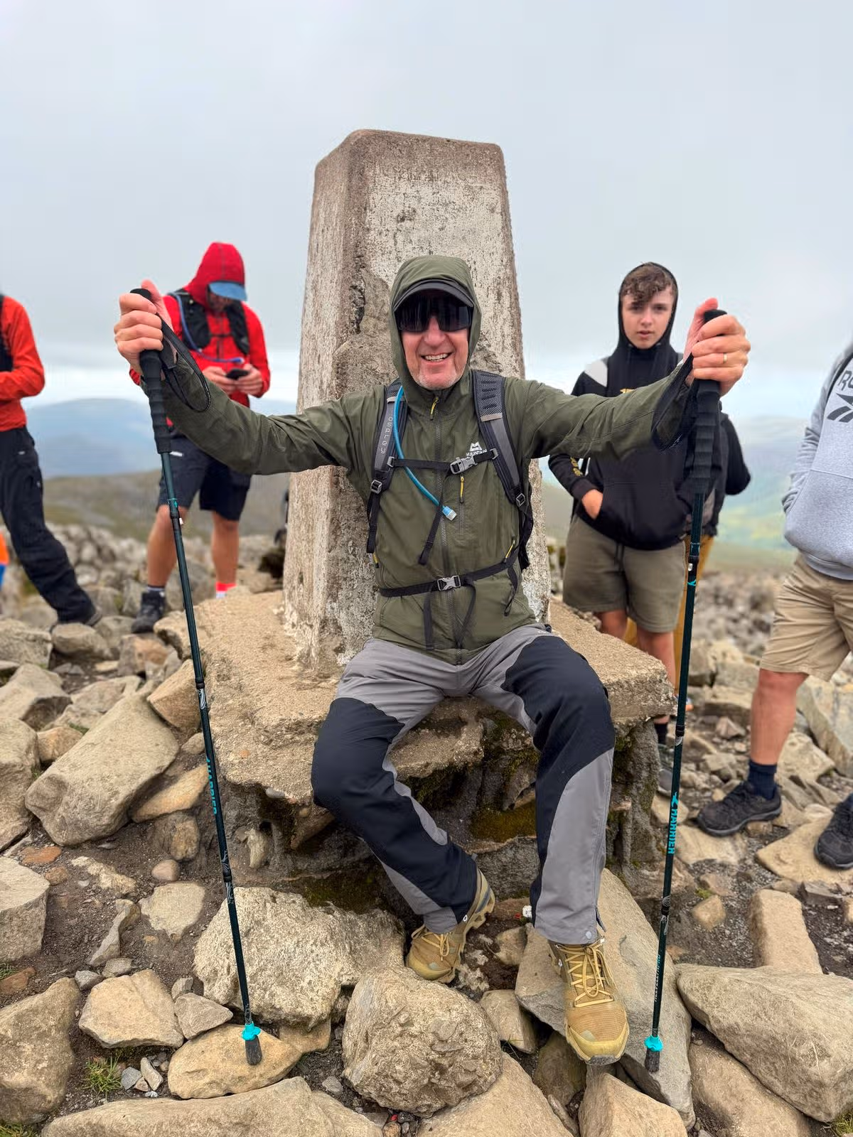 A man in hiking gear at the top of a mountain