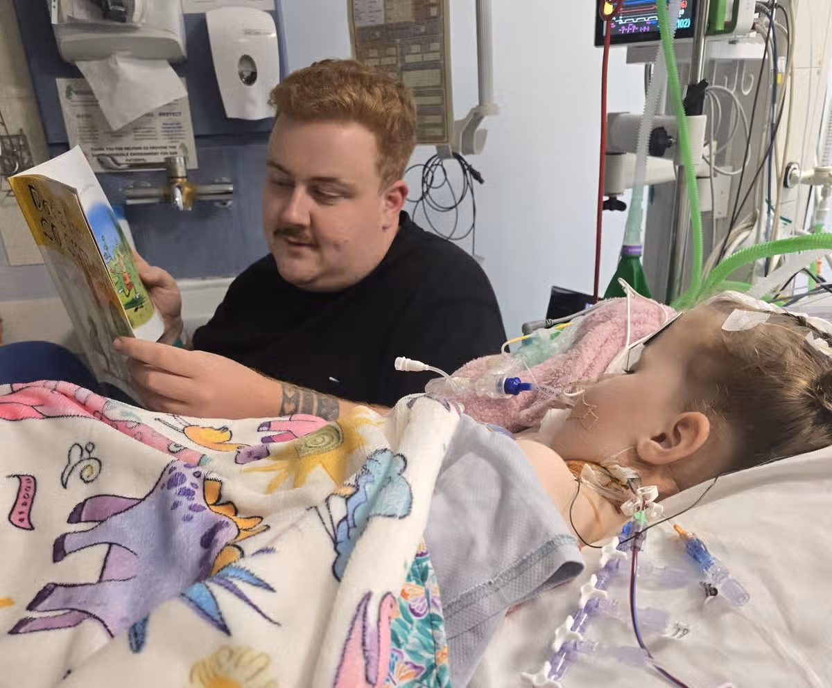 Tom reading to Penny in hospital