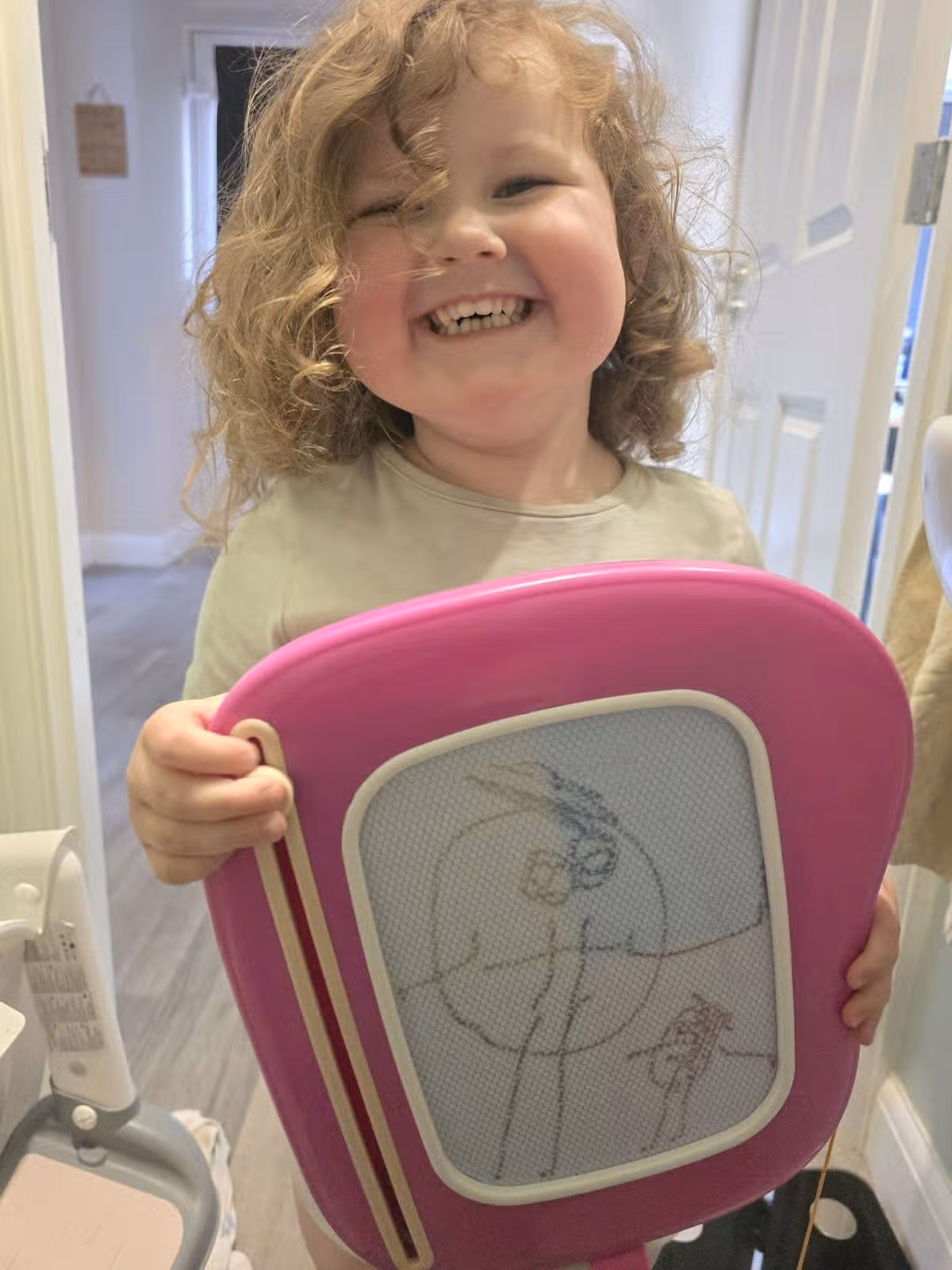 Laughing Penny holding an etch-a-sketch