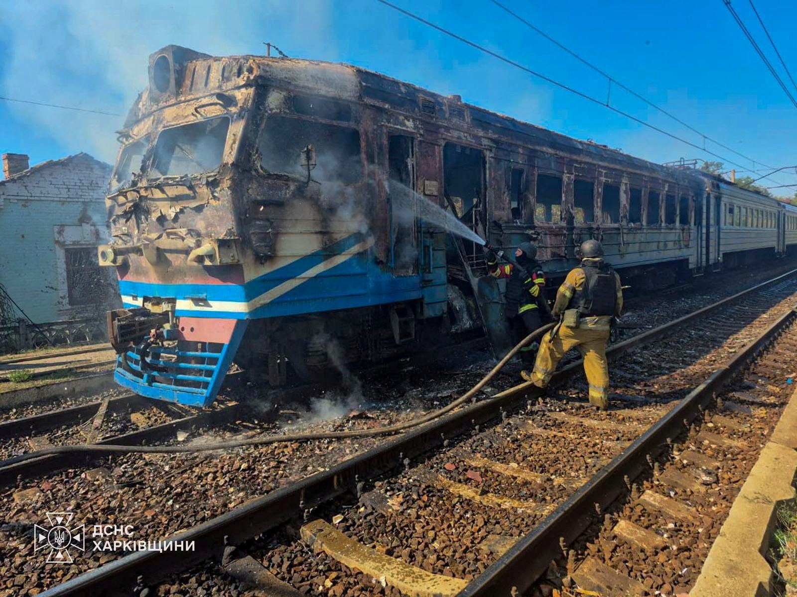 Firefighters extinguish fire on a suburban train which was hit by a Russian drone strike in Kharkiv region