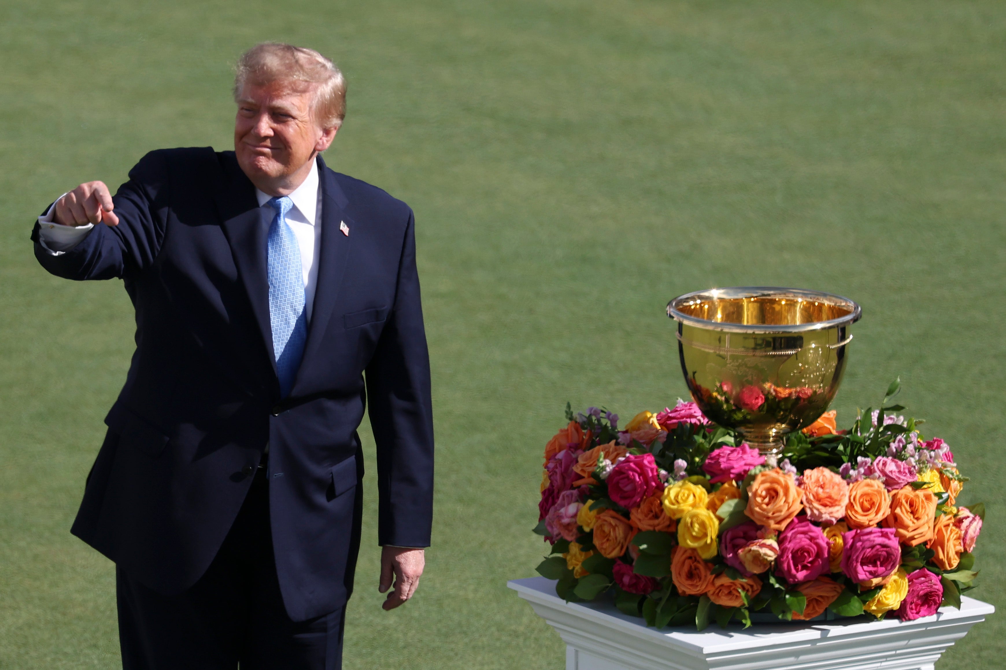 U.S. President Donald Trump reacts to the crowd on the first tee