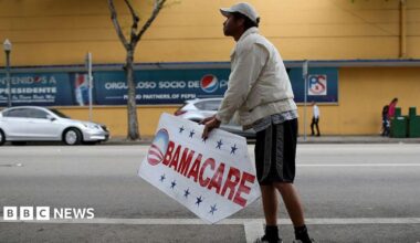 Pedro Rojas holds a sign directing people to an insurance company where they can sign up for the Affordable Care Act, also known as Obamacare on 15 February 2015 in Miami, Florida