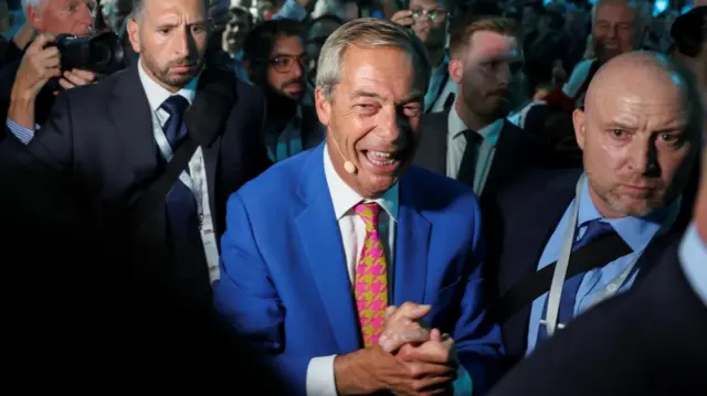 Britain's Reform UK party leader Nigel Farage smiles before speaking at the Reform UK party conference