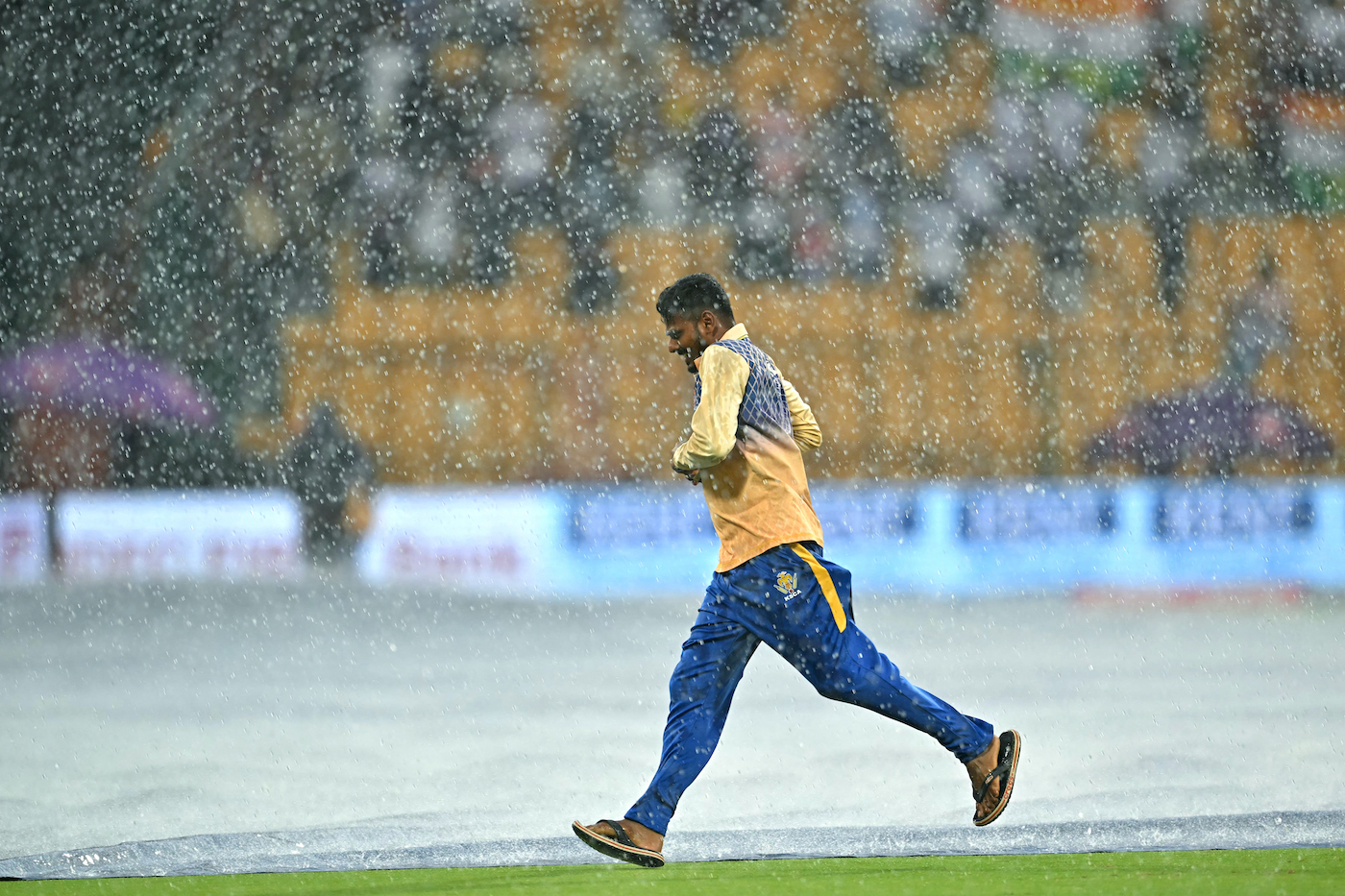 Shower to cover: Ground staff sprint to save the pitch from the rain Shower to cover: Ground staff sprint to save the pitch from the rain