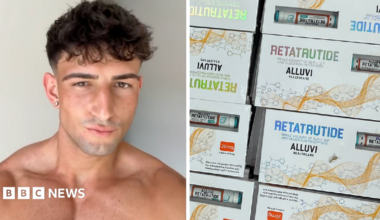 A picture of a young man looking at the camera, He has brown hair and is bare chested. An image of white boxes with retatrutide written in shimmery, colourful writing. The boxes have a little clear window where you can see a vial of fake retatrutide inside