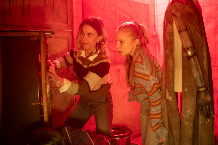 Lynne and her daughter, Amy, in an escape room environment with red lighting