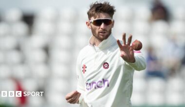 Rob Keogh, wearing sunglasses, catches a ball while preparing to bowl