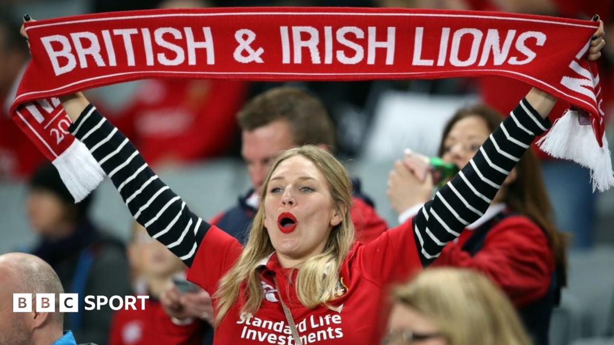 A female lions fan holds up a scarf in the crowd