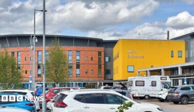 Exterior shot of Salford Royal Hospital. There are a mix of buildings and a car park.