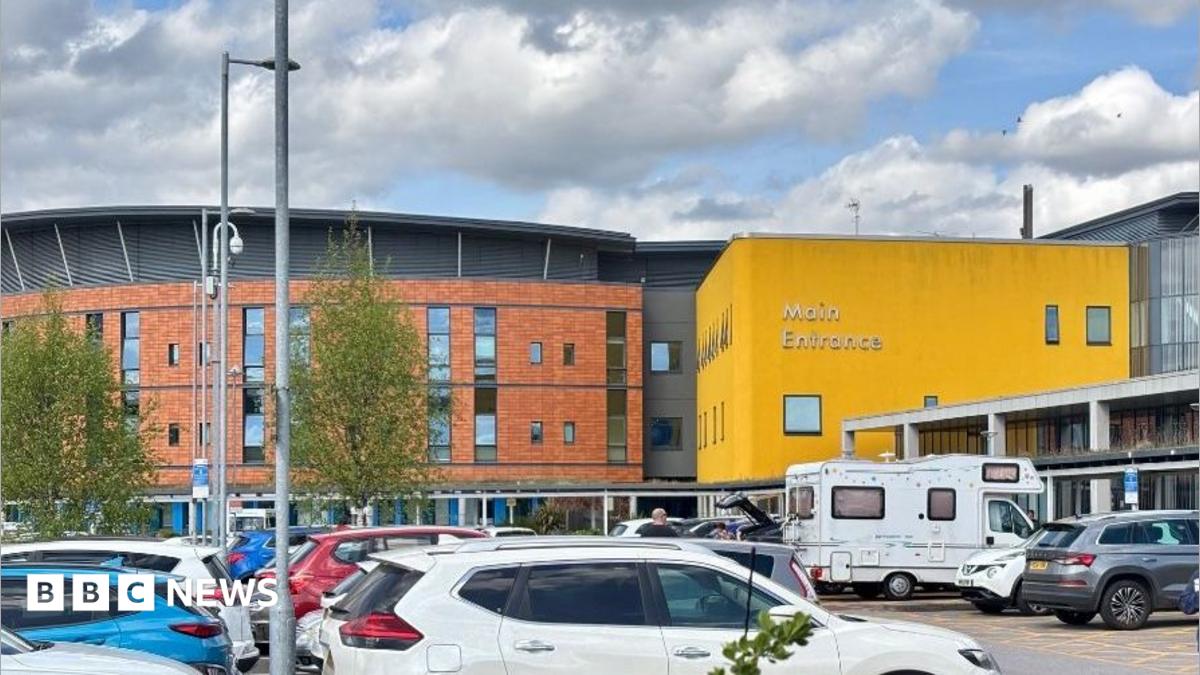 Exterior shot of Salford Royal Hospital. There are a mix of buildings and a car park.
